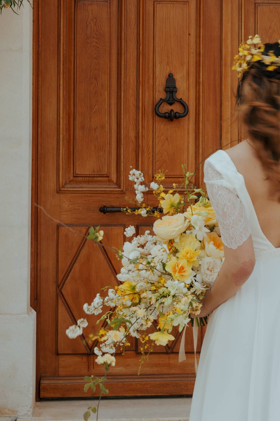 Mariée de dos devant une porte en bois