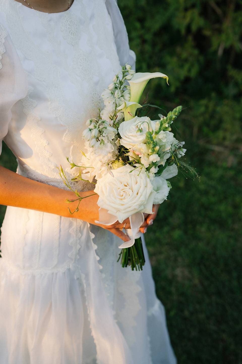 Mariée tenant un bouquet à deux mains